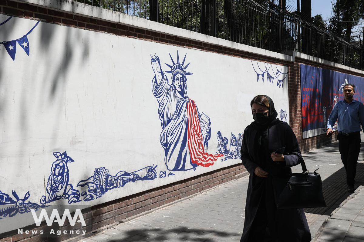 An Iranian woman walks past a wall of the former U.S. Embassy, with an anti-America mural on it, in Tehran, Iran August 16, 2022. Majid Asgaripour/WANA (West Asia News Agency)