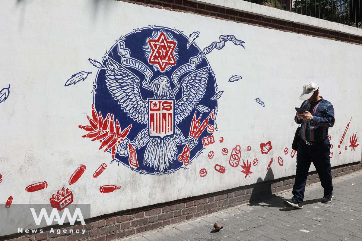 An Iranian man walks past a wall of the former U.S. Embassy, with an anti-America mural on it, in Tehran, Iran August 16, 2022. Majid Asgaripour/WANA (West Asia News Agency)