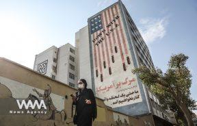 An Iranian woman walks in front of a wall with an anti-American image on it, after Joe Biden wins the US elections, in Tehran, Iran November 8, 2020. Majid Asgaripour/WANA (West Asia News Agency)