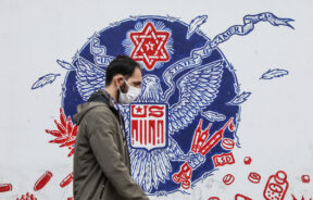 An Iranian man walks in front of the walls of the former US embassy in Tehran with anti-American pictures on it, after Joe Biden wins the US elections, in Tehran, Iran November 8, 2020. Majid Asgaripour/WANA (West Asia News Agency)