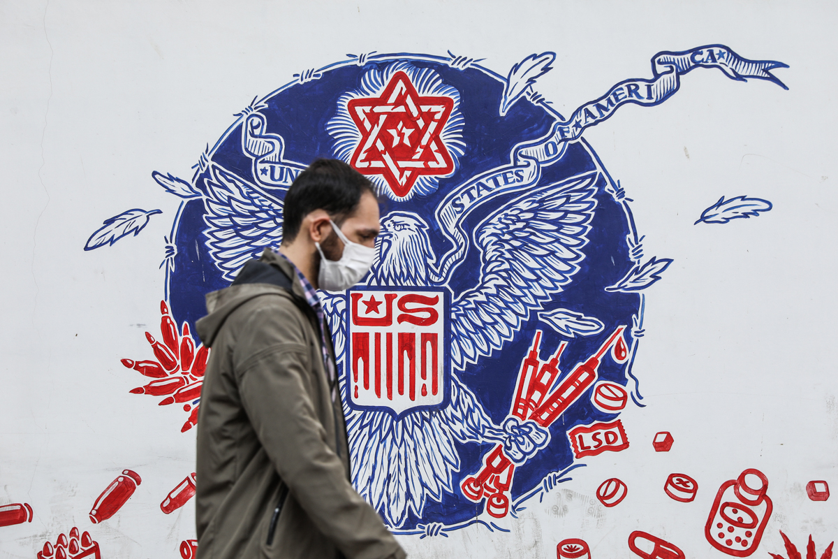 An Iranian man walks in front of the walls of the former US embassy in Tehran with anti-American pictures on it, after Joe Biden wins the US elections, in Tehran, Iran November 8, 2020. Majid Asgaripour/WANA (West Asia News Agency)