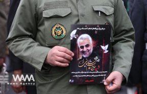 An Iranian guard holds a picture of the late Iranian Major-General Qassem Soleimani during the gathering to mourn for General Qassem Soleimani head of the elite Quds Force, and Iraqi militia commander Abu Mahdi al-Muhandis, who were killed in an air strike at Baghdad airport, in Tehran, Iran January 4, 2020. Nazanin Tabatabaee/WANA (West Asia News Agency)