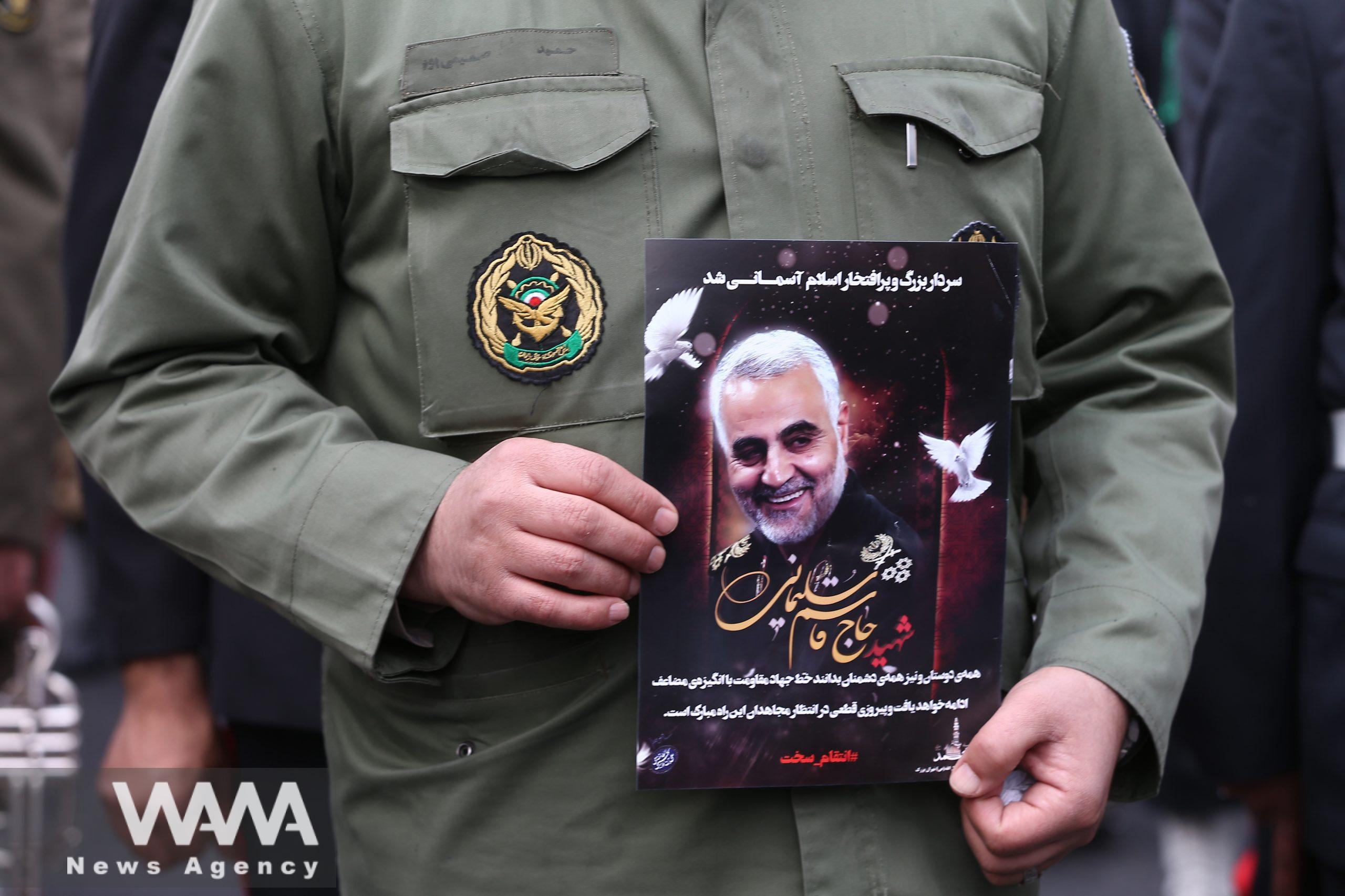 An Iranian guard holds a picture of the late Iranian Major-General Qassem Soleimani during the gathering to mourn for General Qassem Soleimani head of the elite Quds Force, and Iraqi militia commander Abu Mahdi al-Muhandis, who were killed in an air strike at Baghdad airport, in Tehran, Iran January 4, 2020. Nazanin Tabatabaee/WANA (West Asia News Agency)