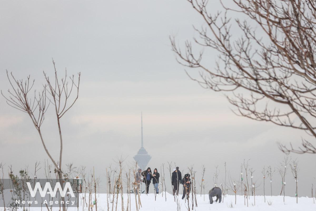 People walk during the first snowfall in a park in Tehran, Iran December 24, 2022. Majid Asgaripour/WANA (West Asia News Agency)