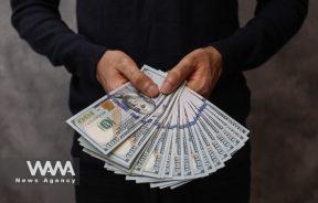 A currency dealer holds U.S. dollars in an exchange shop in Tehran, Iran December 25, 2022. Majid Asgaripour/WANA (West Asia News Agency)