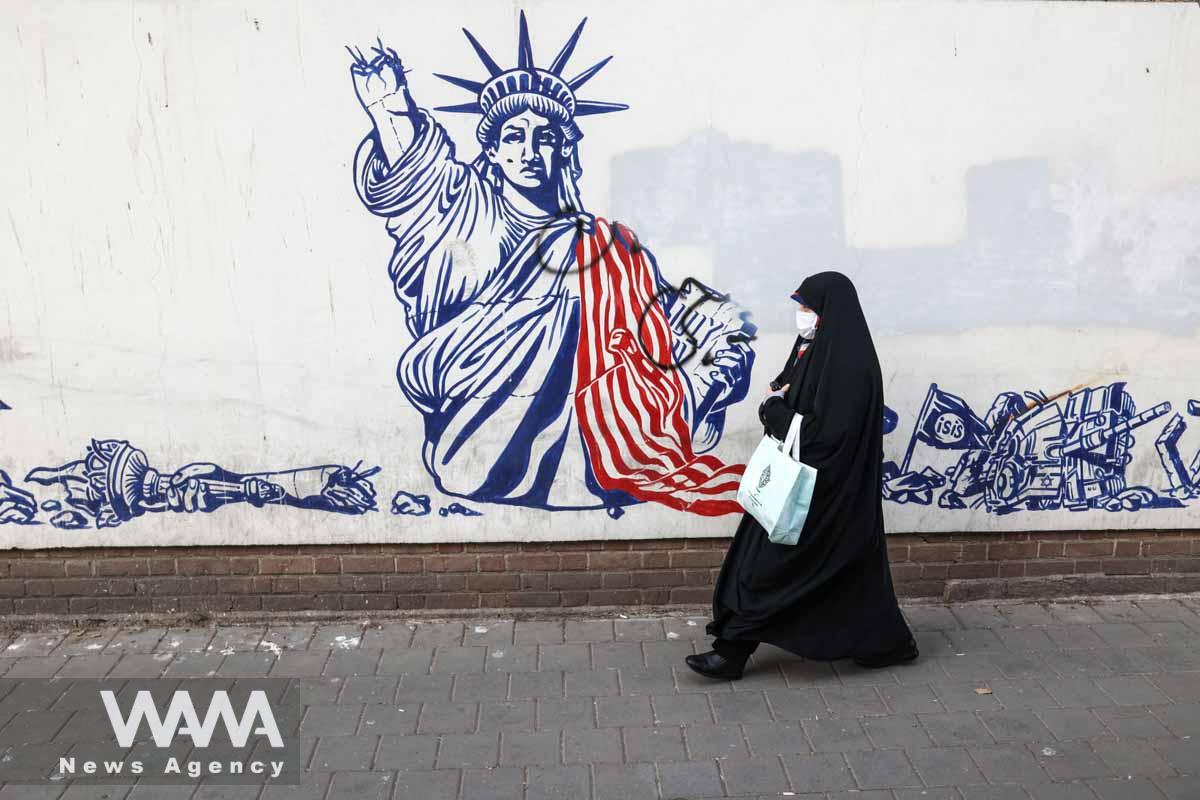 An Iranian woman walks past an anti-U.S. mural on the wall of former U.S. Embassy in Tehran, Iran January 25, 2023. Majid Asgaripour/WANA (West Asia News Agency)