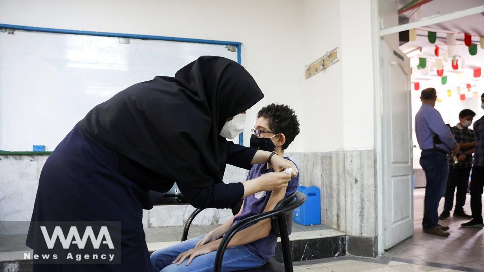 An Iranian teenager receives a dose of a vaccine against the coronavirus disease (COVID-19) at a school in Tehran WANA News Agency