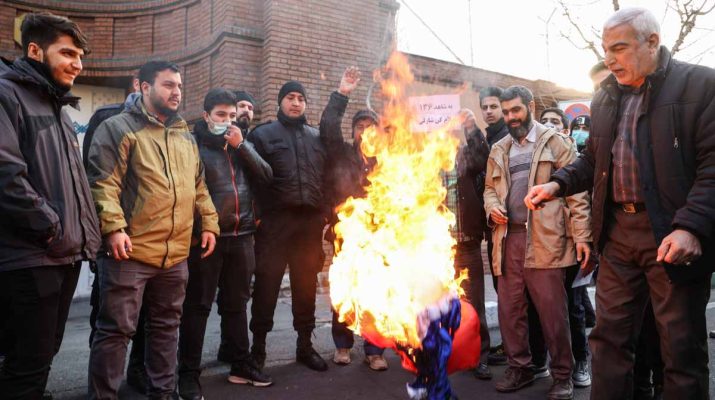 Demonstrators burn a French flag during a protest to condemn the French magazine Charlie Hebdo for republishing cartoons insulting Iran's Supreme Leader Ayatollah Ali Khamenei, in front of the French Embassy in Tehran, Iran, January 8, 2023. Majid Asgaripour/WANA (West Asia News Agency)