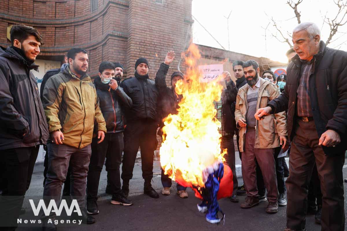 Demonstrators burn a French flag during a protest to condemn the French magazine Charlie Hebdo for republishing cartoons insulting Iran's Supreme Leader Ayatollah Ali Khamenei, in front of the French Embassy in Tehran, Iran, January 8, 2023. Majid Asgaripour/WANA (West Asia News Agency)