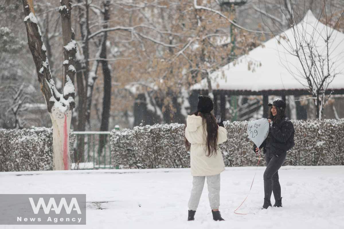 An Iranian woman takes a photo in a park in Tehran during snowfall in Tehran, Iran, January 15, 2023. Majid Asgaripour/WANA (West Asia News Agency)