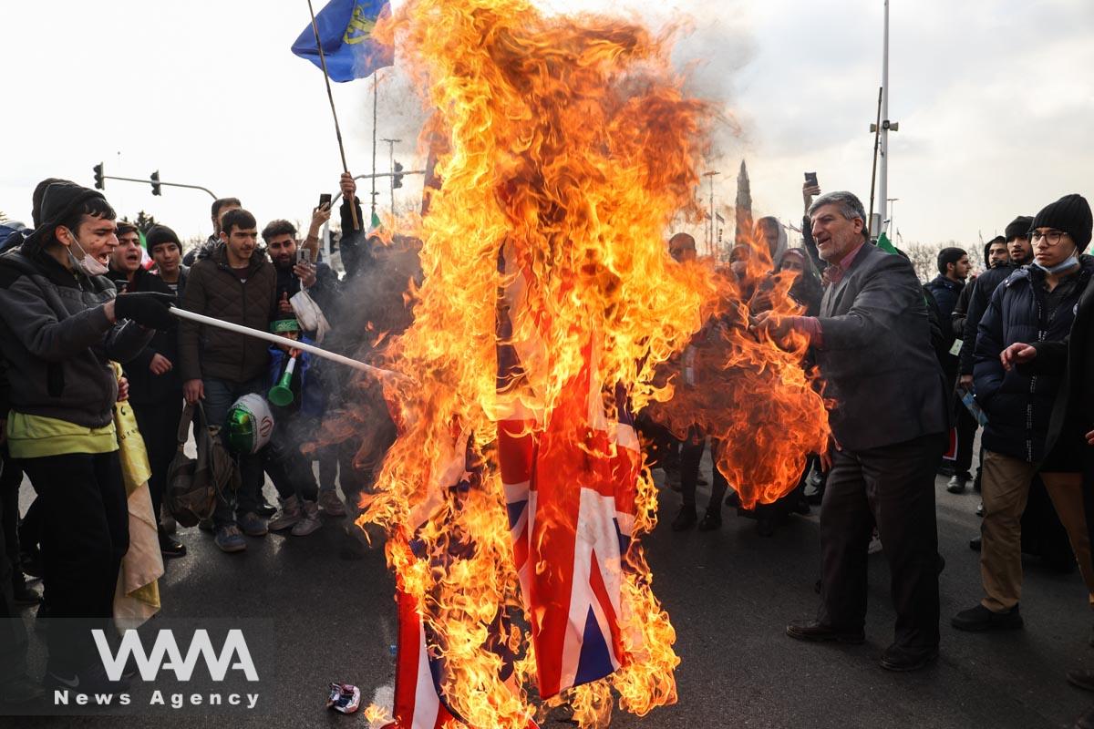 Iranian set fire to American and British flags during the 44th anniversary of the Islamic Revolution in Tehran, Iran, February 11, 2023. Majid Asgaripour/WANA (West Asia News Agency)