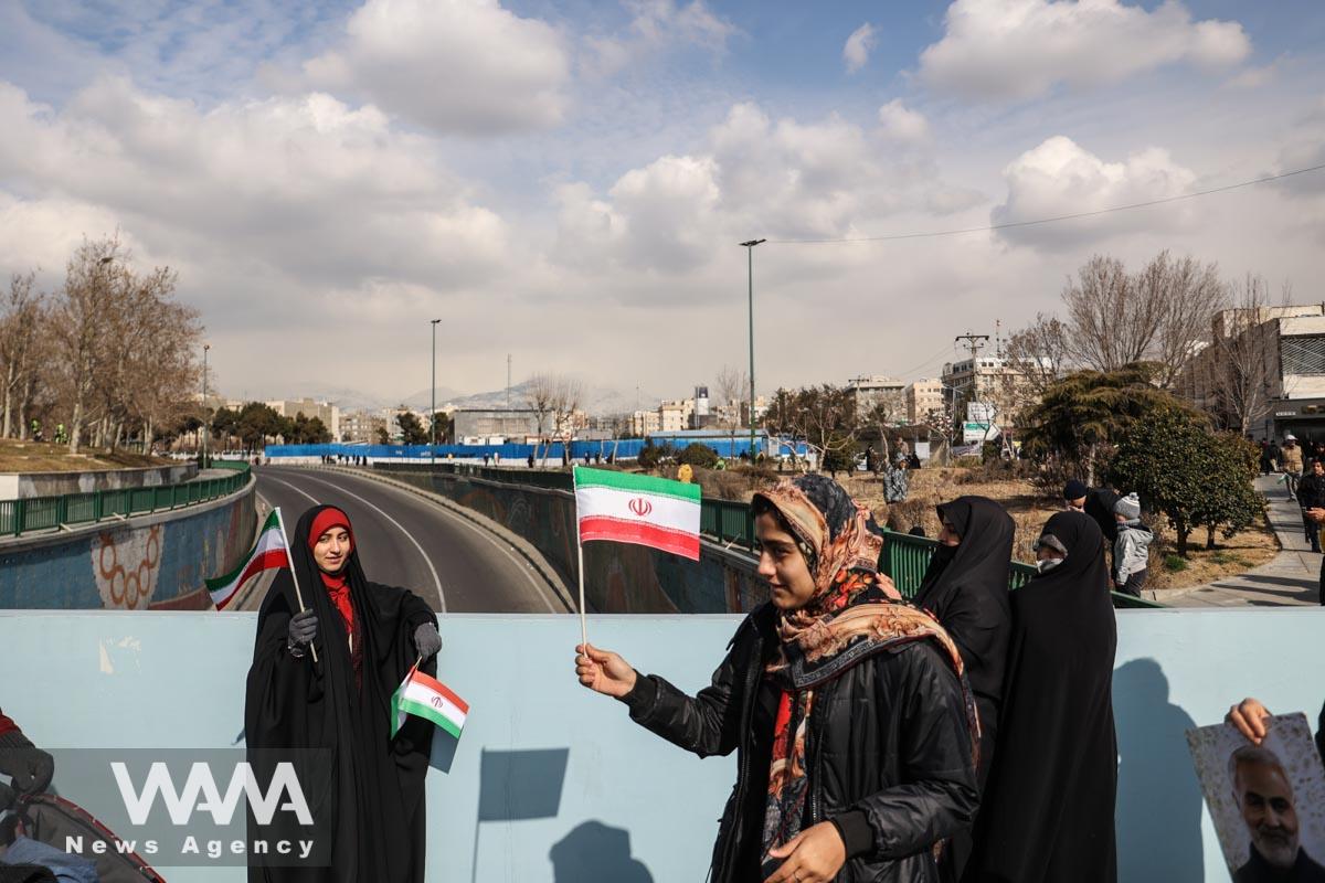 Iranian women hold the Iranian flag during the 44th anniversary of the Islamic Revolution in Tehran, Iran, February 11, 2023. Majid Asgaripour/WANA (West Asia News Agency)