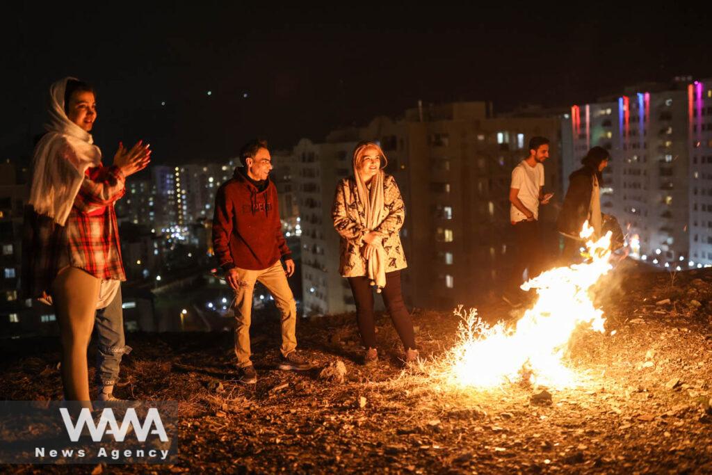 Iranians stand by the fire during the Wednesday Fire celebration (Chahar Shanbeh Soori in Persian) in a park in Tehran, Iran March 14, 2023. Majid Asgaripour/WANA (West Asia News Agency)