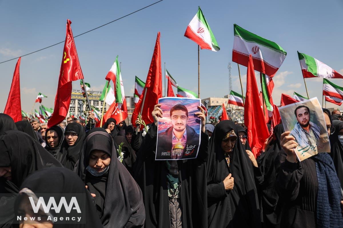 An Iranian woman holds picture of Meghdad Mahghani a member of Iran's Islamic Revolution Guards Corps (IRGC) who was killed in an Israeli airstrike on Damascus, held in Tehran, Iran, April 4, 2023. Majid Asgaripour/WANA (West Asia News Agency)