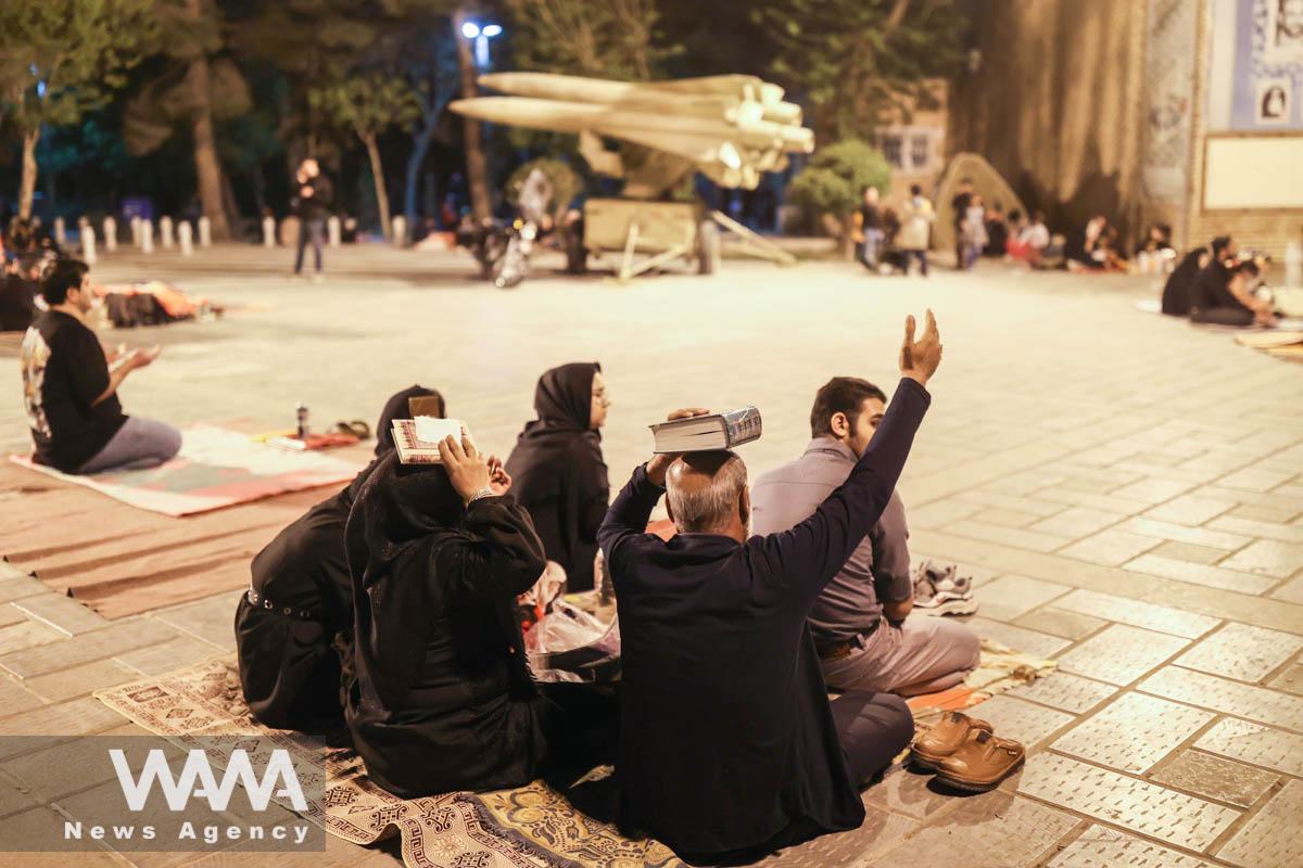 Iranian Shiite Muslims place copies of the Quran on their heads while praying in Laylat al-Qadr, during the holy month of Ramadan in Behesht-e-Zahra Cemetery in south of Tehran, Iran, April 9, 2023. Majid Asgaripour/WANA (West Asia News Agency)