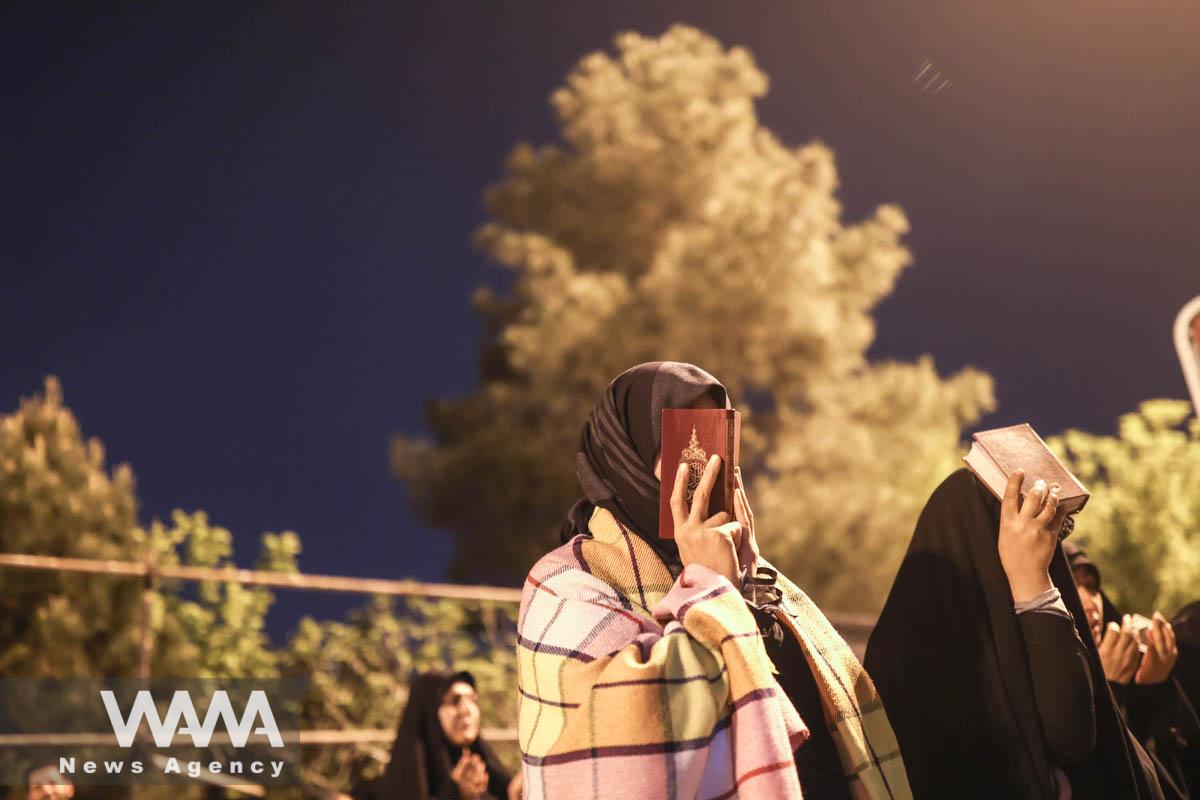 Iranian Shiite Muslims place copies of the Quran on their heads while praying in Laylat al-Qadr, during the holy month of Ramadan in Behesht-e-Zahra Cemetery in south of Tehran, Iran, April 10, 2023. Majid Asgaripour/WANA (West Asia News Agency)