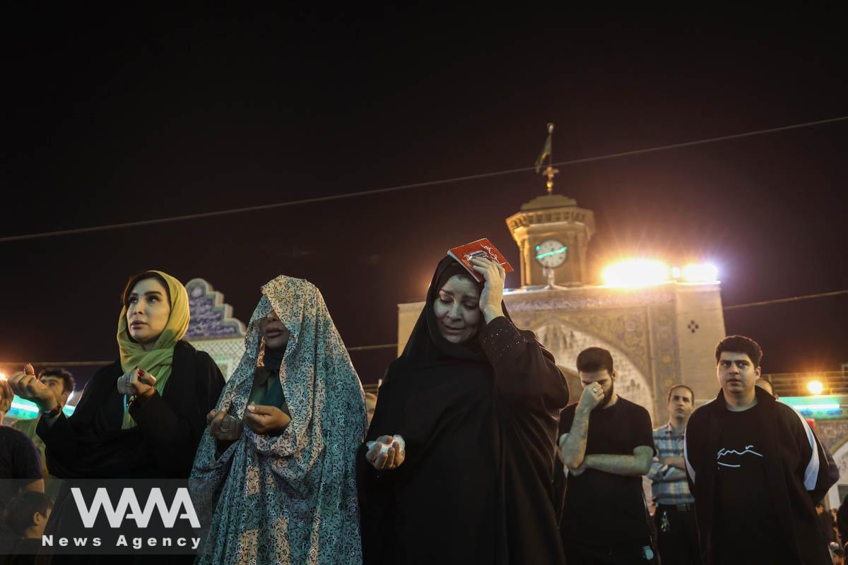 Iranian Shiite Muslims place copies of the Quran on their heads while marking the death anniversary of Imam Ali, during the holy month of Ramadan, at the shrine of Abdol-Azim in Tehran, Iran, April 12, 2023. Majid Asgaripour/WANA (West Asia News Agency)