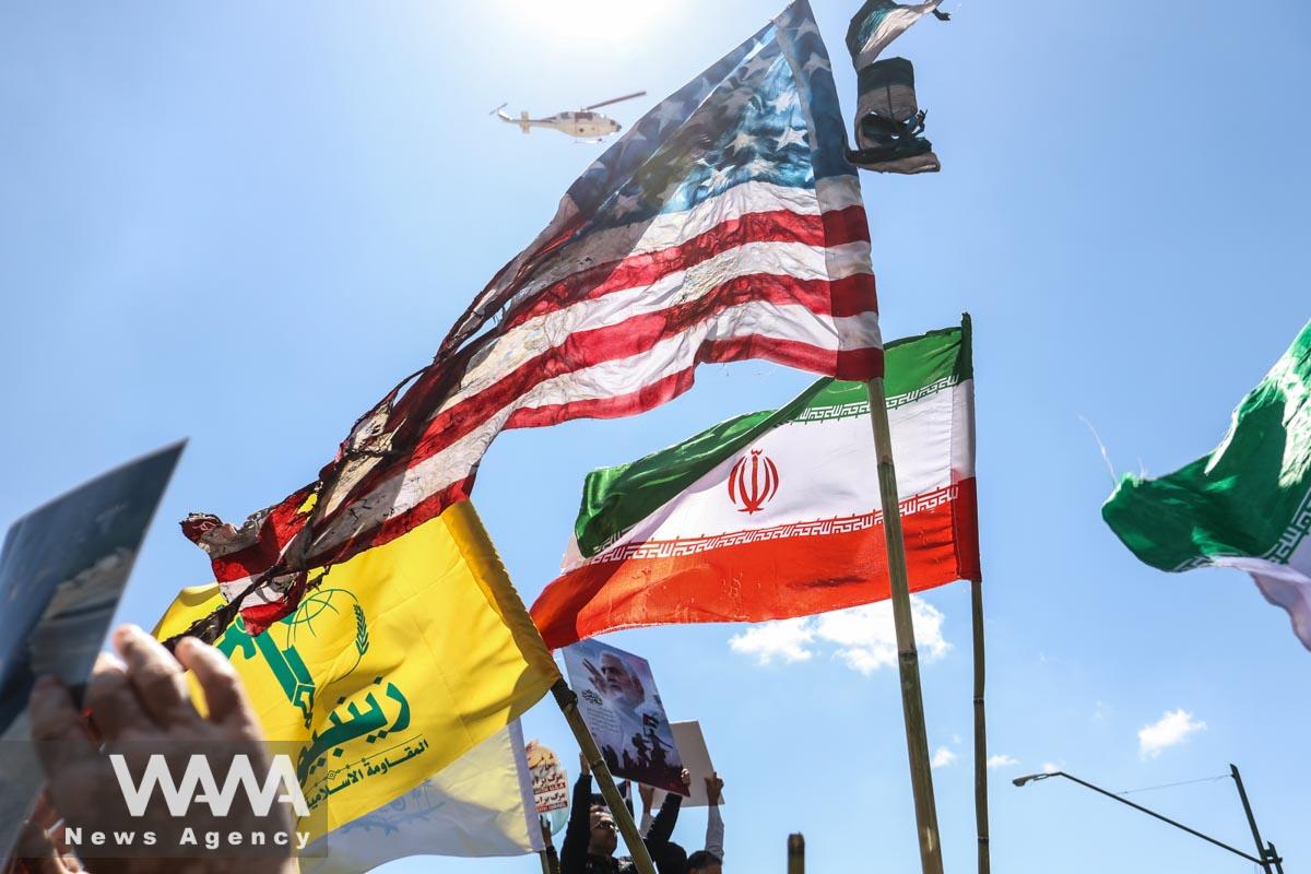 A burned US flag next to an Iranian flag is seen during a rally marking the annual Quds Day, or Jerusalem Day, on the last Friday of the holy month of Ramadan in Tehran, Iran April 14, 2023. Majid Asgaripour/WANA (West Asia News Agency)