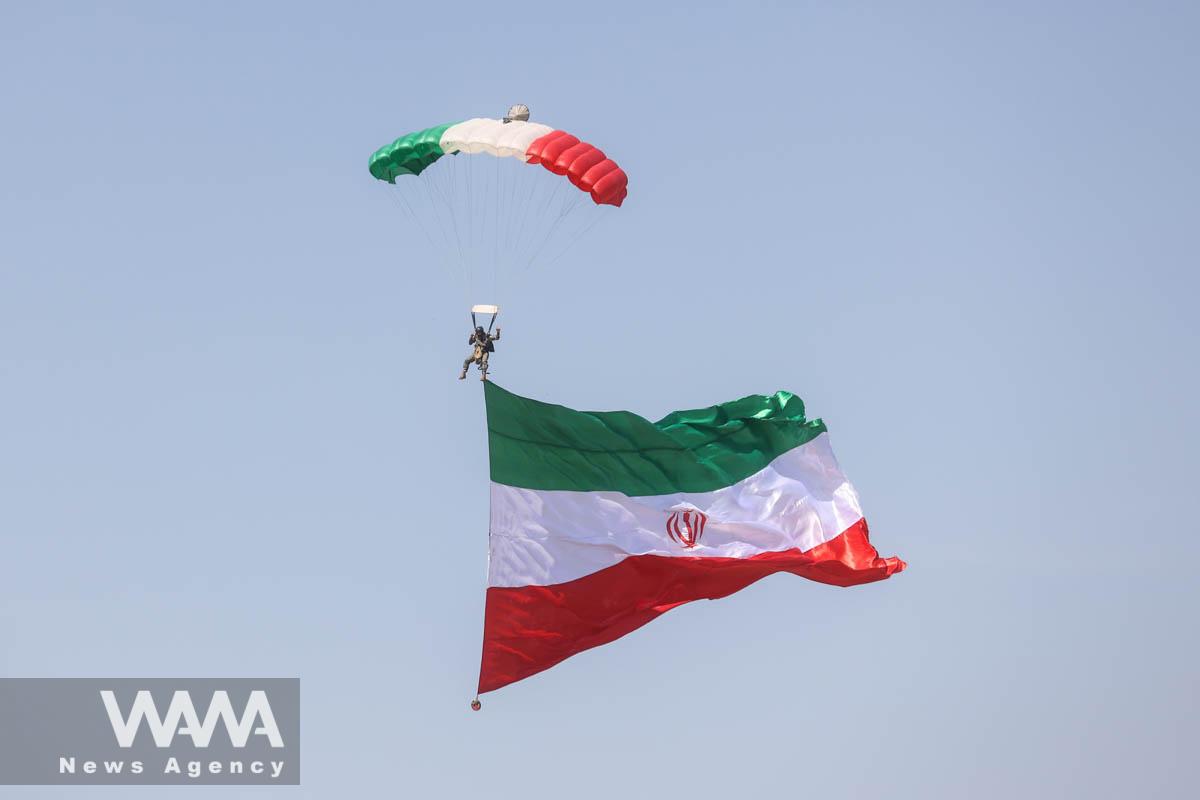 An Iranian paratrooper carries the Iranian flag during a ceremony of the National Army Day parade in Tehran, Iran, April 18, 2023. Majid Asgaripour/WANA (West Asia News Agency)
