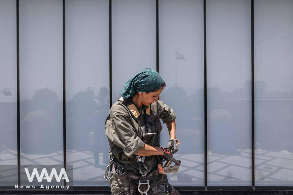 An Iranian female Sogand Salari wears her safety-harness as she gets ready to clean windows of highrise buildings in Tehran, Iran June 20, 2023. Majid Asgaripour/WANA (West Asia News Agency)