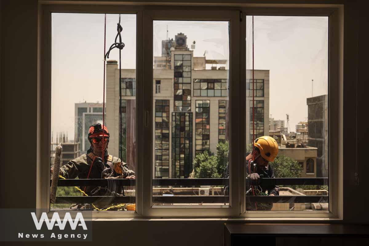 An Iranian female Sogand Salari cleans windows of a high-rise building in Tehran, Iran June 20, 2023. Majid Asgaripour/WANA (West Asia News Agency)