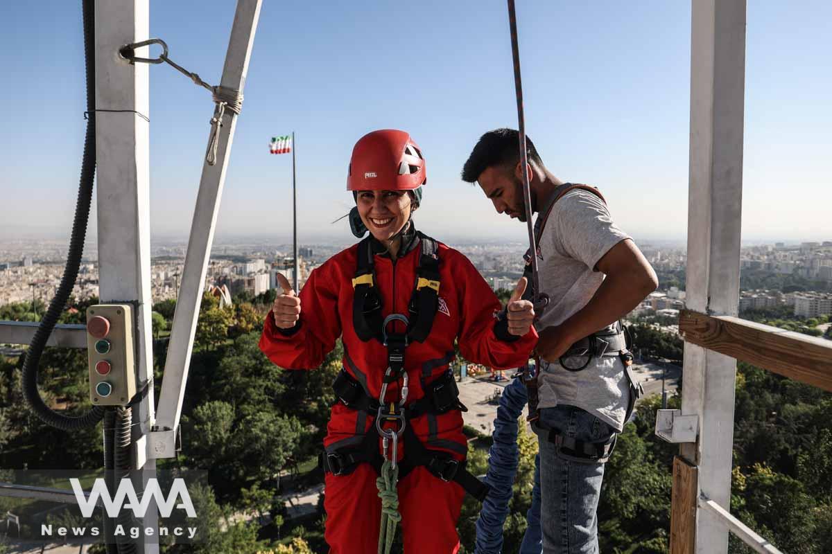 An Iranian female Sogand Salari gives thumbs up as she gets strapped for her bungee-jumping experience, at Adrenaline Park in Tehran, Iran June 21, 2023. Majid Asgaripour/WANA (West Asia News Agency)