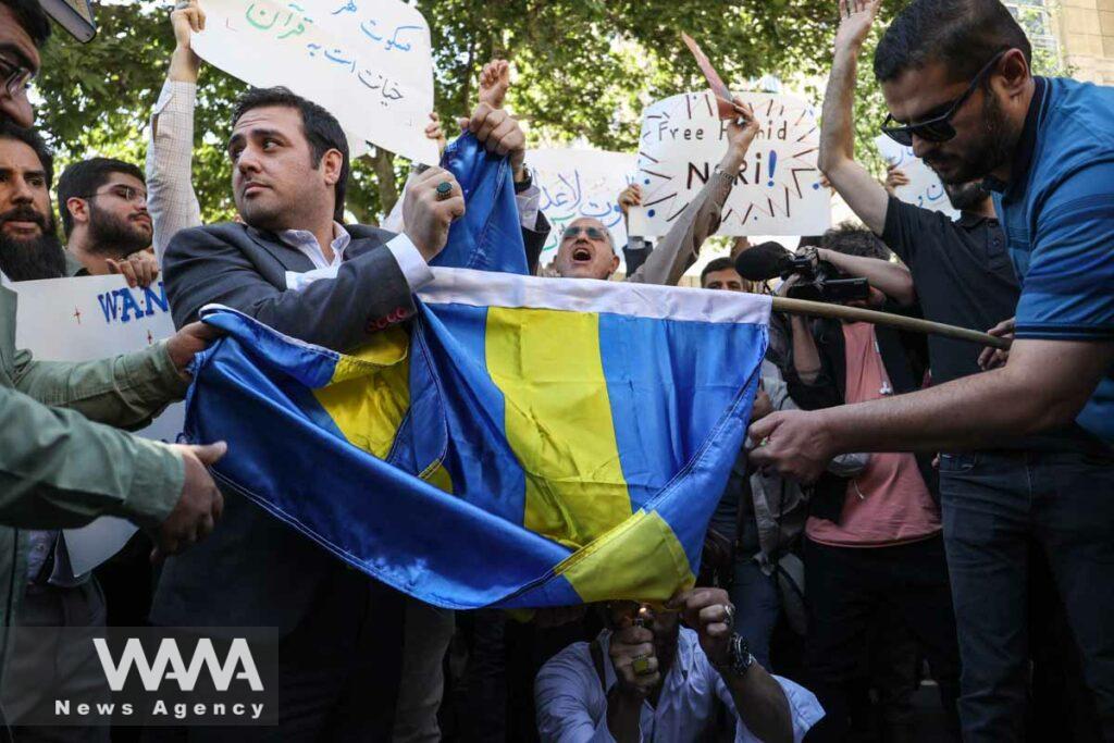 Demonstrators burn the Sweden flag during a protest against a man who burned a copy of the Quran outside a mosque in the Swedish capital Stockholm, in front of the Swedish Embassy in Tehran, Iran June 30, 2023. Majid Asgaripour/WANA (West Asia News Agency)