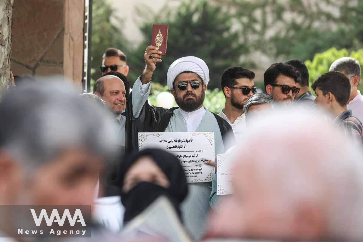 An Iranian cleric holds the Quran in his hand during a protest against a man who burned a copy of the Quran outside a mosque in the Swedish capital Stockholm, in front of the Swedish Embassy in Tehran, Iran July 3, 2023. Majid Asgaripour/WANA (West Asia News Agency)