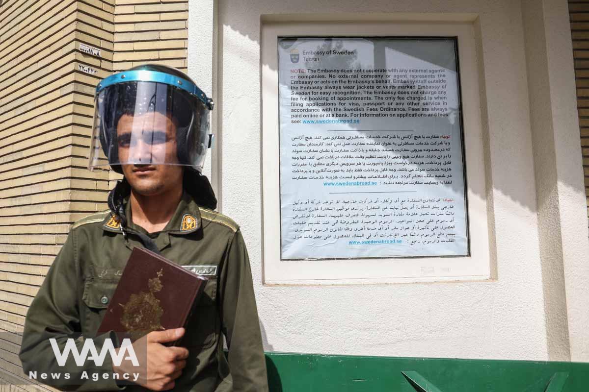 A policeman stands guard with a Quran in his hand outside the Swedish Embassy during a protest against a man who burned a copy of the Quran outside a mosque in the Swedish capital Stockholm, in Tehran, Iran July 3, 2023. Majid Asgaripour/WANA (West Asia News Agency)