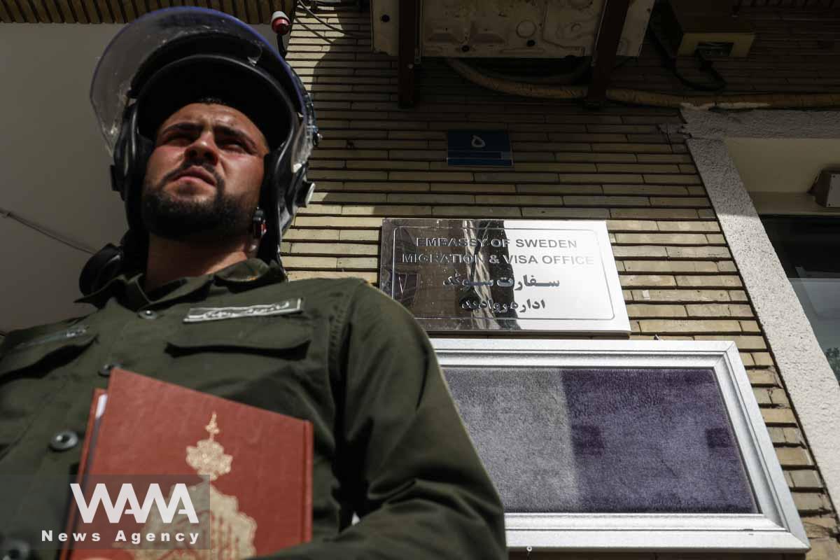 A policeman stands guard with a Quran in his hand outside the Swedish Embassy during a protest against a man who burned a copy of the Quran outside a mosque in the Swedish capital Stockholm, in Tehran, Iran July 3, 2023. Majid Asgaripour/WANA (West Asia News Agency)