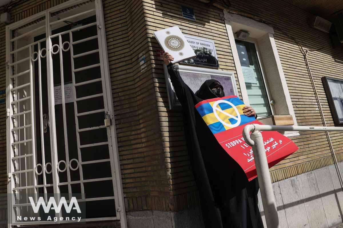 An Iranian protester holds the Quran in her hand during a protest against a man who burned a copy of the Quran outside a mosque in the Swedish capital Stockholm, in front of the Swedish Embassy in Tehran, Iran July 3, 2023. Majid Asgaripour/WANA (West Asia News Agency)