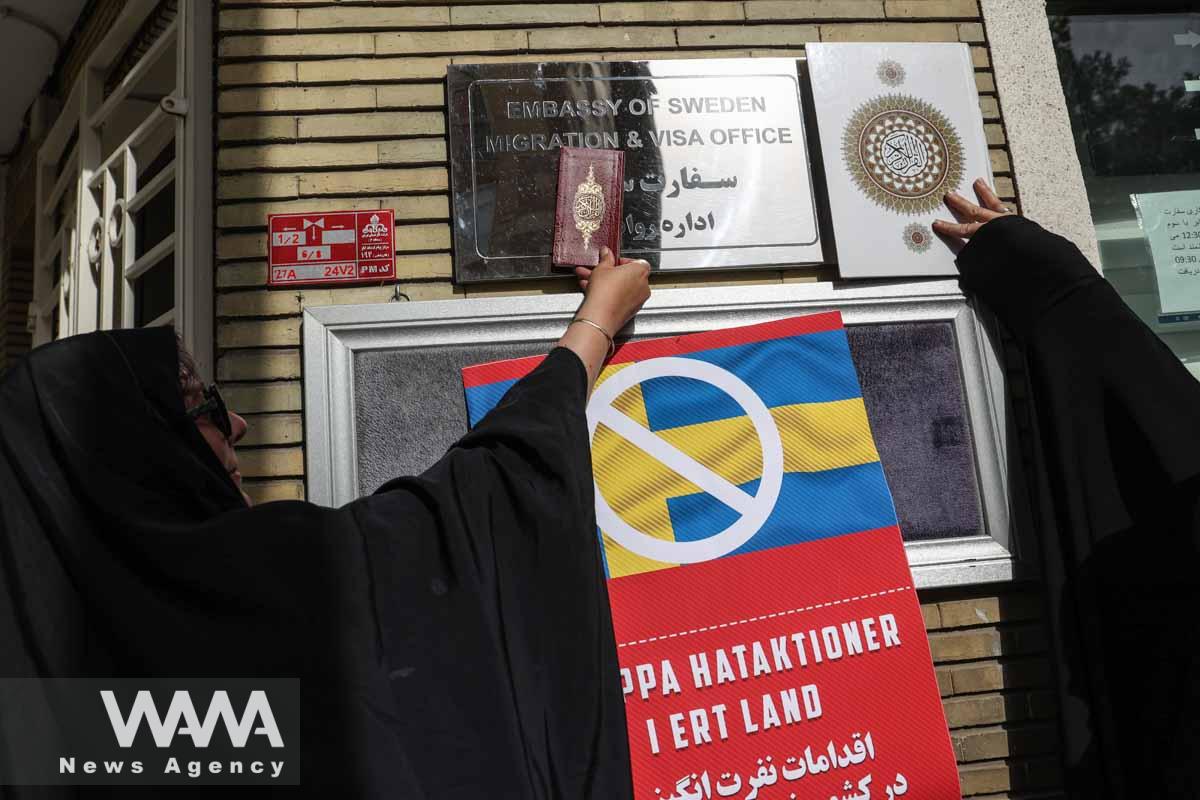 Demonstrators place the Quran next to the sign of the Swedish Embassy during a protest against a man who burned a copy of the Quran outside a mosque in the Swedish capital Stockholm, in front of the Swedish Embassy in Tehran, Iran July 3, 2023. Majid Asgaripour/WANA (West Asia News Agency)