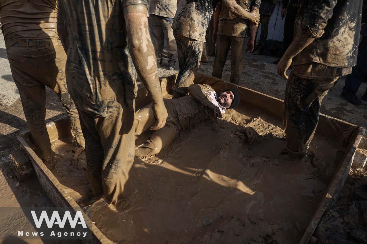 An Iranian Shi'ite Muslim immerses himself in mud during a ceremony to mark Ashura, the holiest day on the Shi'ite Muslim calendar, in Tehran, Iran July 28, 2023. Majid Asgaripour/WANA (West Asia News Agency)