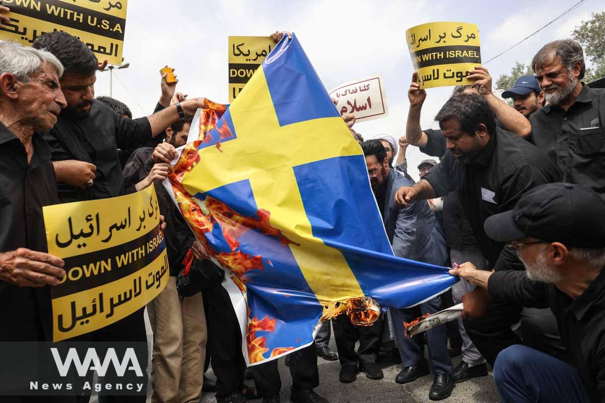 Demonstrators burn the Swedish flag during a protest against the insult to the Koran in Stockholm, in Tehran, Iran July 21, 2023. Majid Asgaripour/WANA (West Asia News Agency)