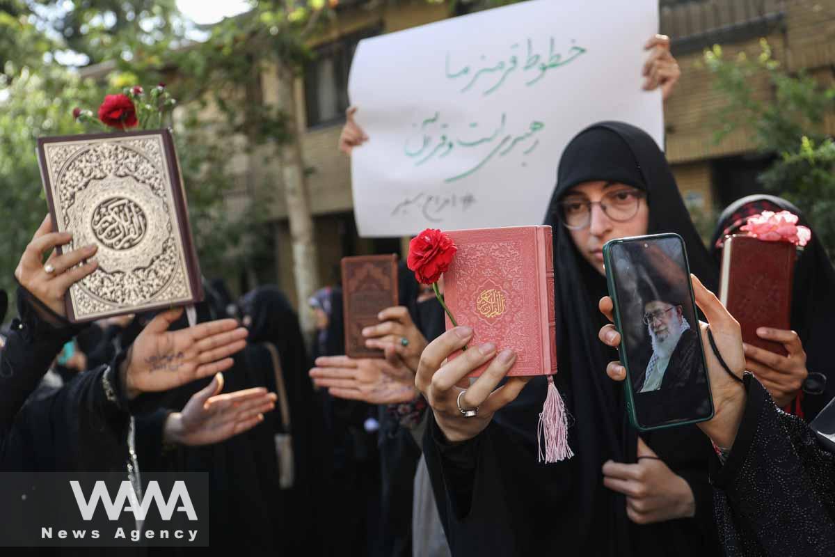 An Iranian protester holds the Koran in her hand during a protest against the insult to the Koran in Stockholm, in front of the Swedish Embassy in Tehran, Iran July 21, 2023. Majid Asgaripour/WANA (West Asia News Agency)