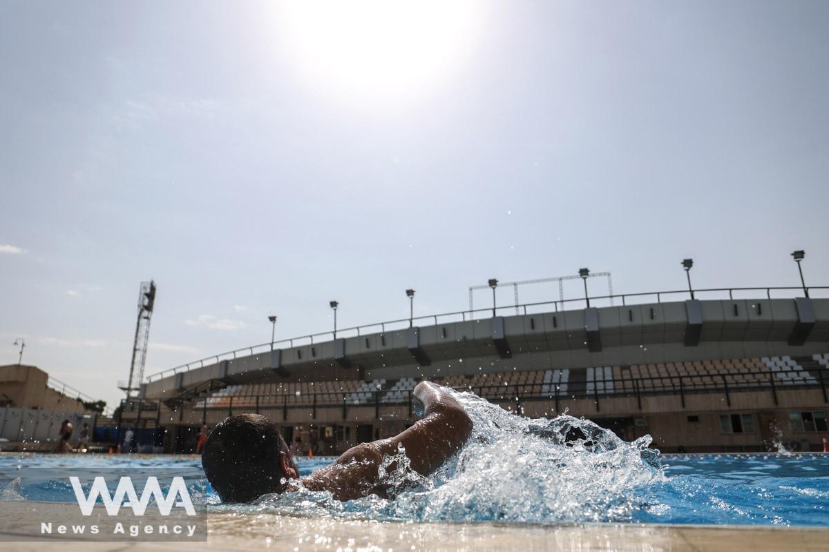 An Iranian man swims in a pool during the heat surge in Tehran, Iran August 3, 2023. Majid Asgaripour/WANA (West Asia News Agency)