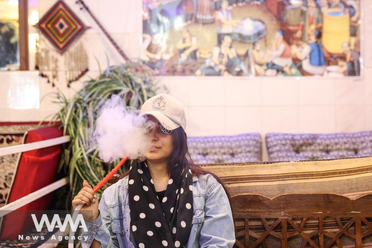 An Iranian woman smokes a hookah in a restaurant in Tehran, Iran October 6, 2021. Majid Asgaripour/WANA (West Asia News Agency)