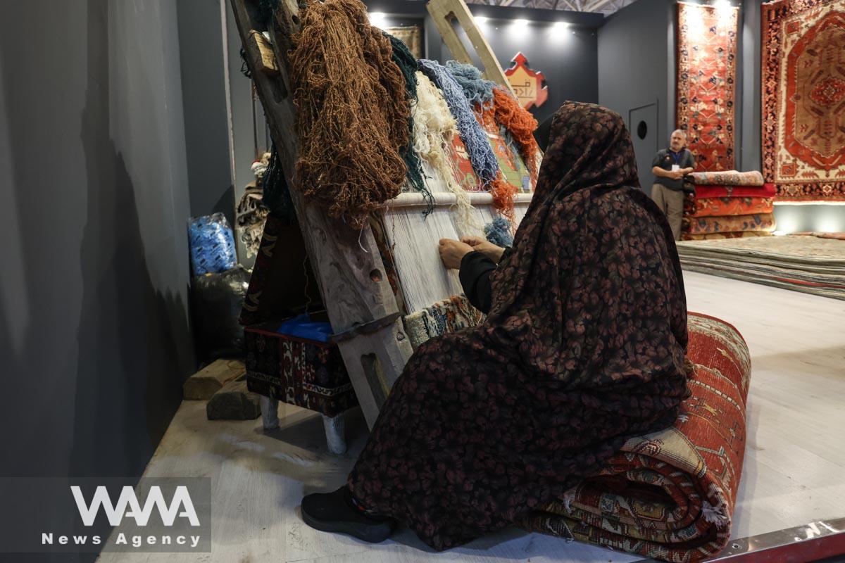 An Iranian woman weaves a carpet during the 30th Handmade Carpet Exhibition in Tehran, Iran August 26, 2023. Majid Asgaripour/WANA (West Asia News Agency)