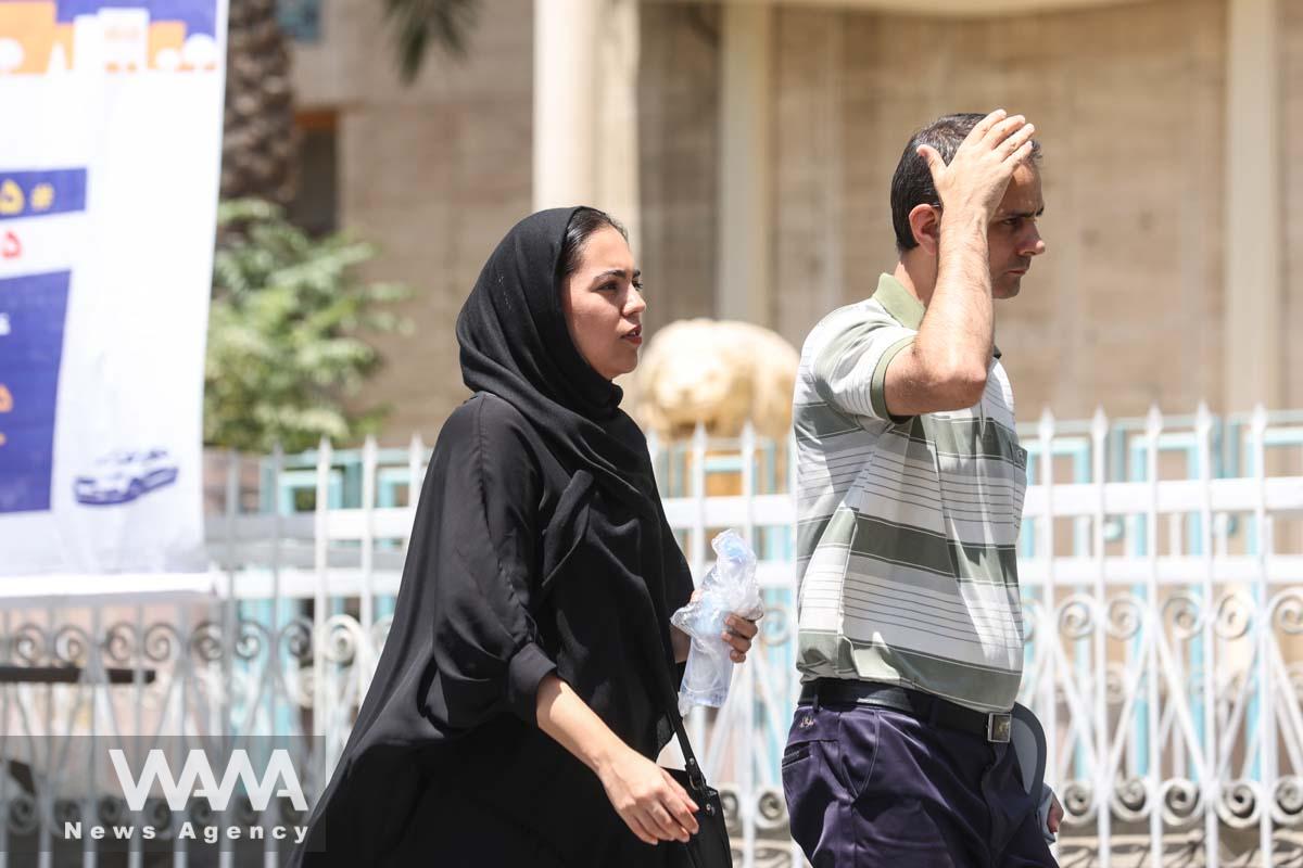 Iranians walk in a street during the heat surge in Tehran, Iran August 2, 2023. Majid Asgaripour/WANA (West Asia News Agency)