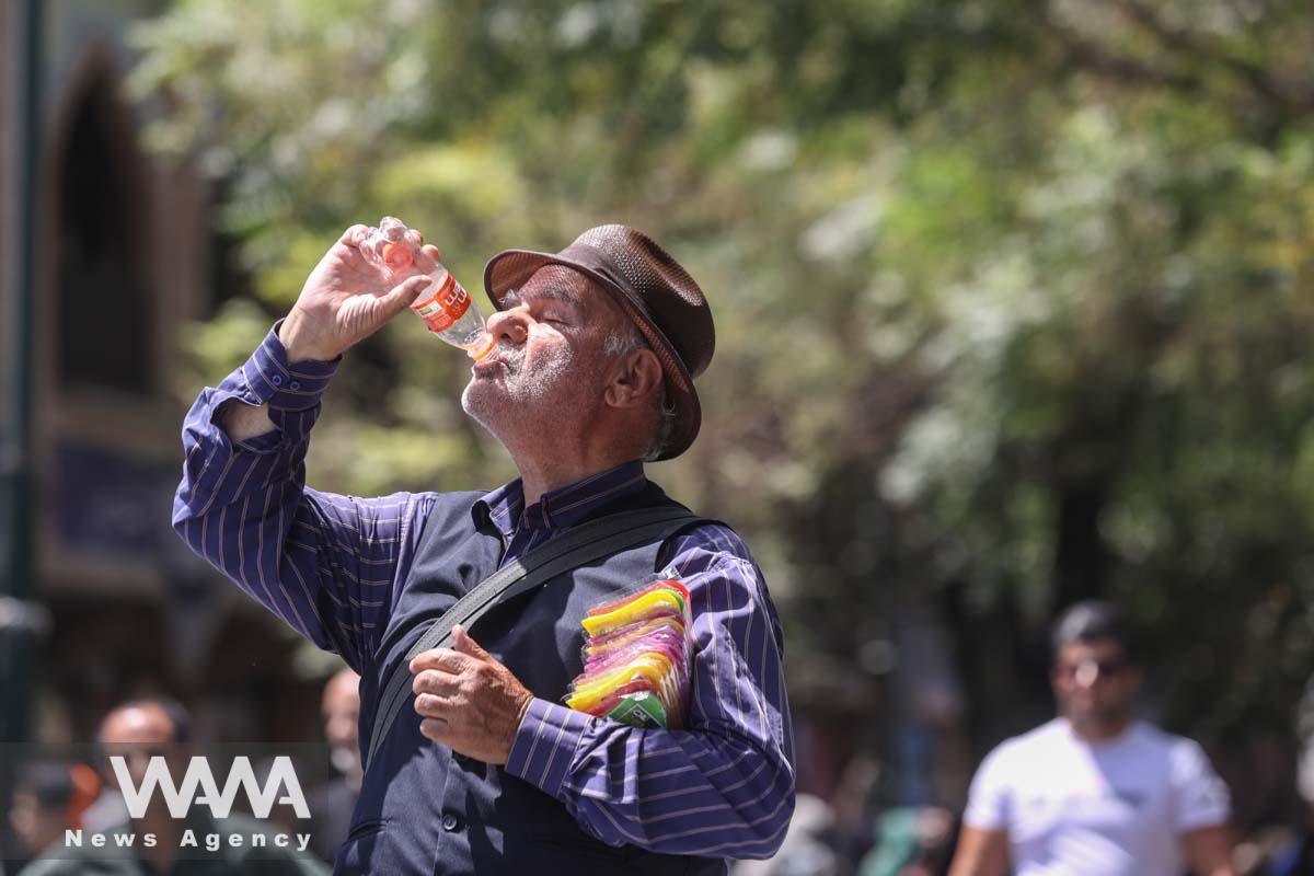 An Iranian man drinks soda during the heat surge in Tehran, Iran August 2, 2023. Majid Asgaripour/WANA (West Asia News Agency)