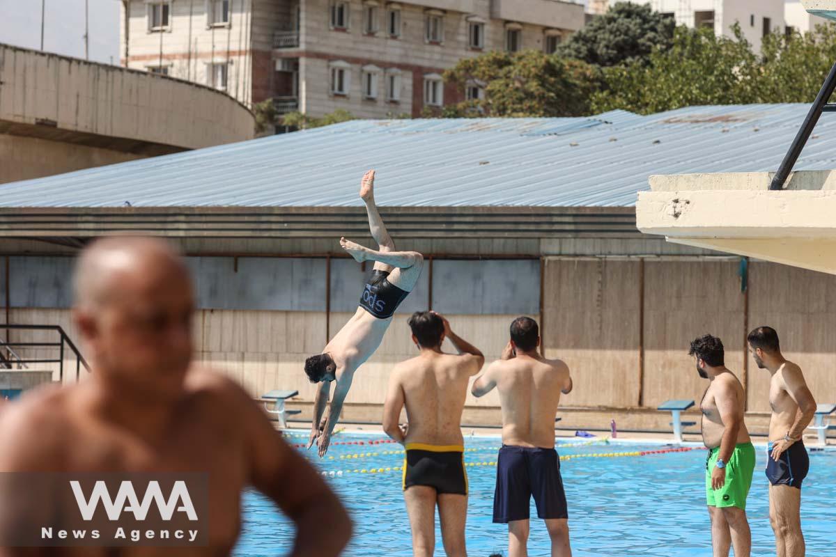 An Iranian man dives in a pool during the heat surge in Tehran, Iran August 3, 2023. Majid Asgaripour/WANA (West Asia News Agency)