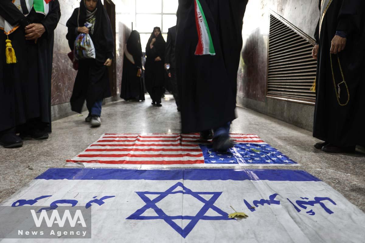 An Iranian woman steps on the Israeli flag during an anti-Israel protest in/