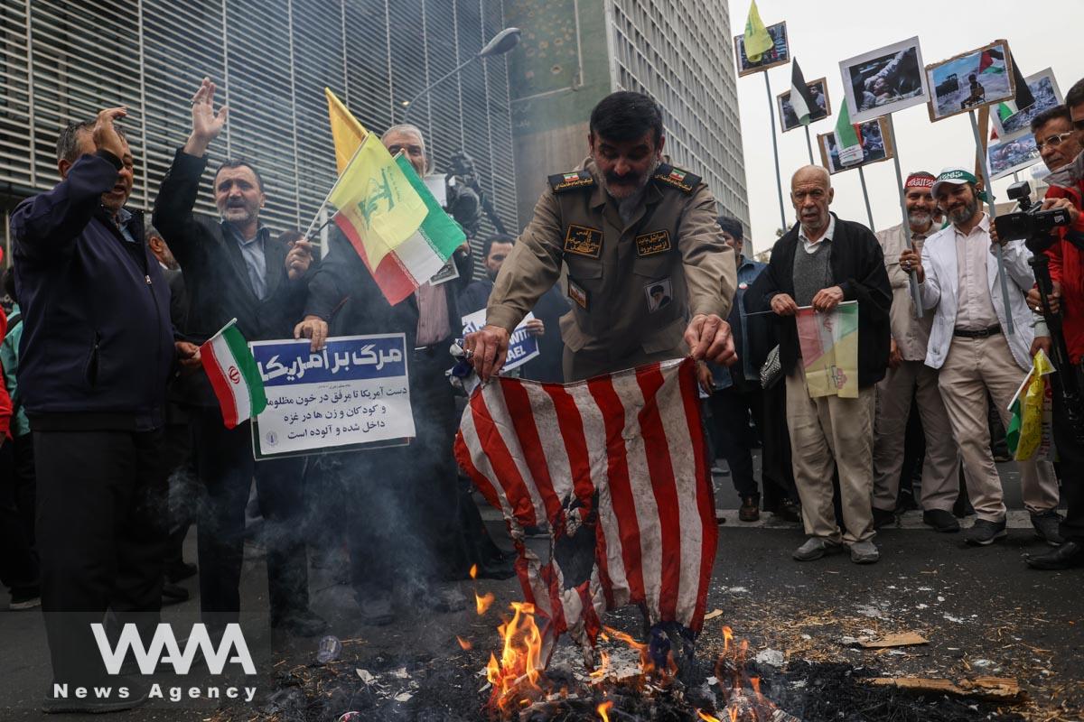 An Iranian man burns an American flag during the 44th anniversary of the U.S. expulsion from Iran/WANA (West Asia News Agency)