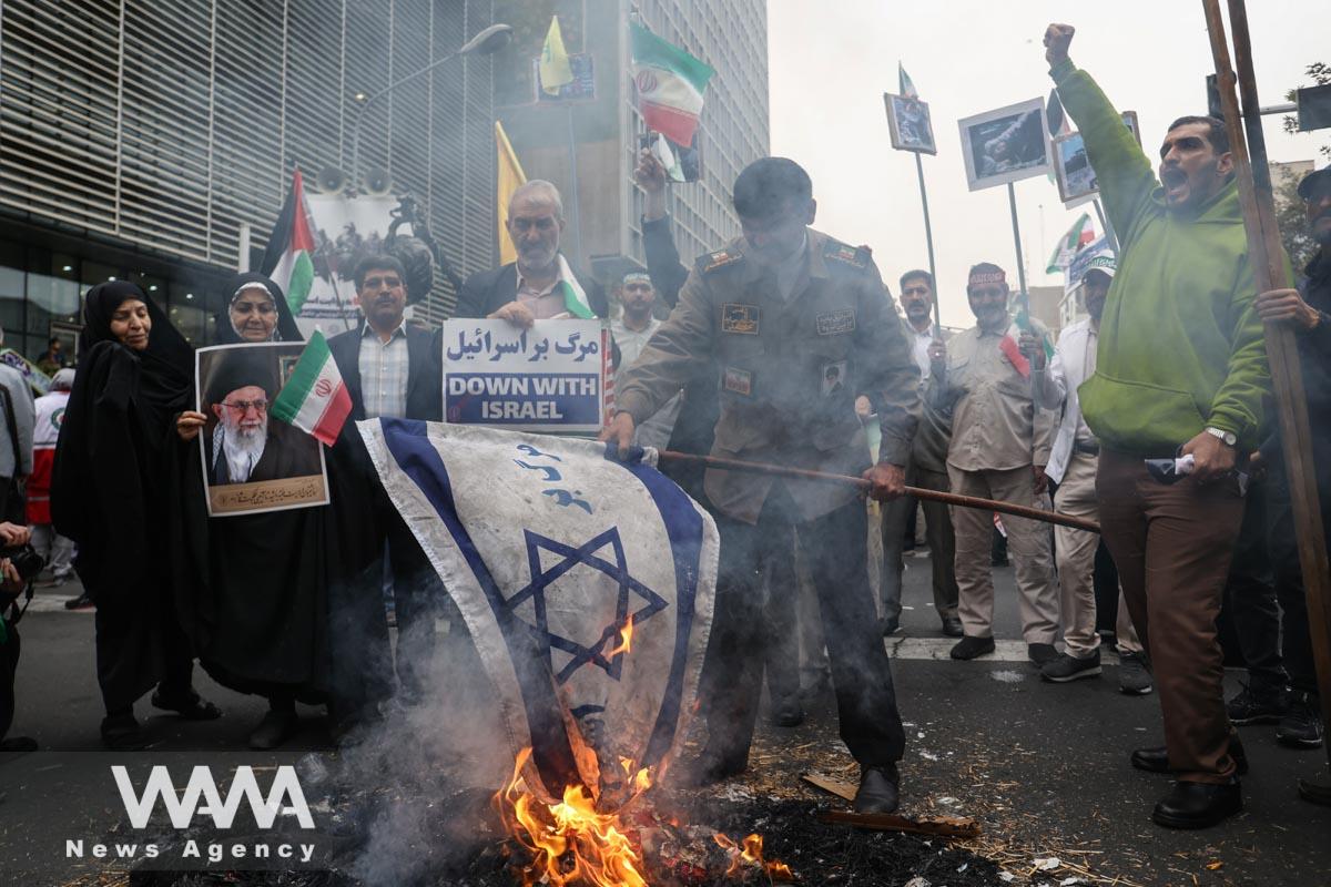 An Iranian man burns an Israeli flag during the 44th anniversary of the U.S. expulsion from Iran/WANA (West Asia News Agency)