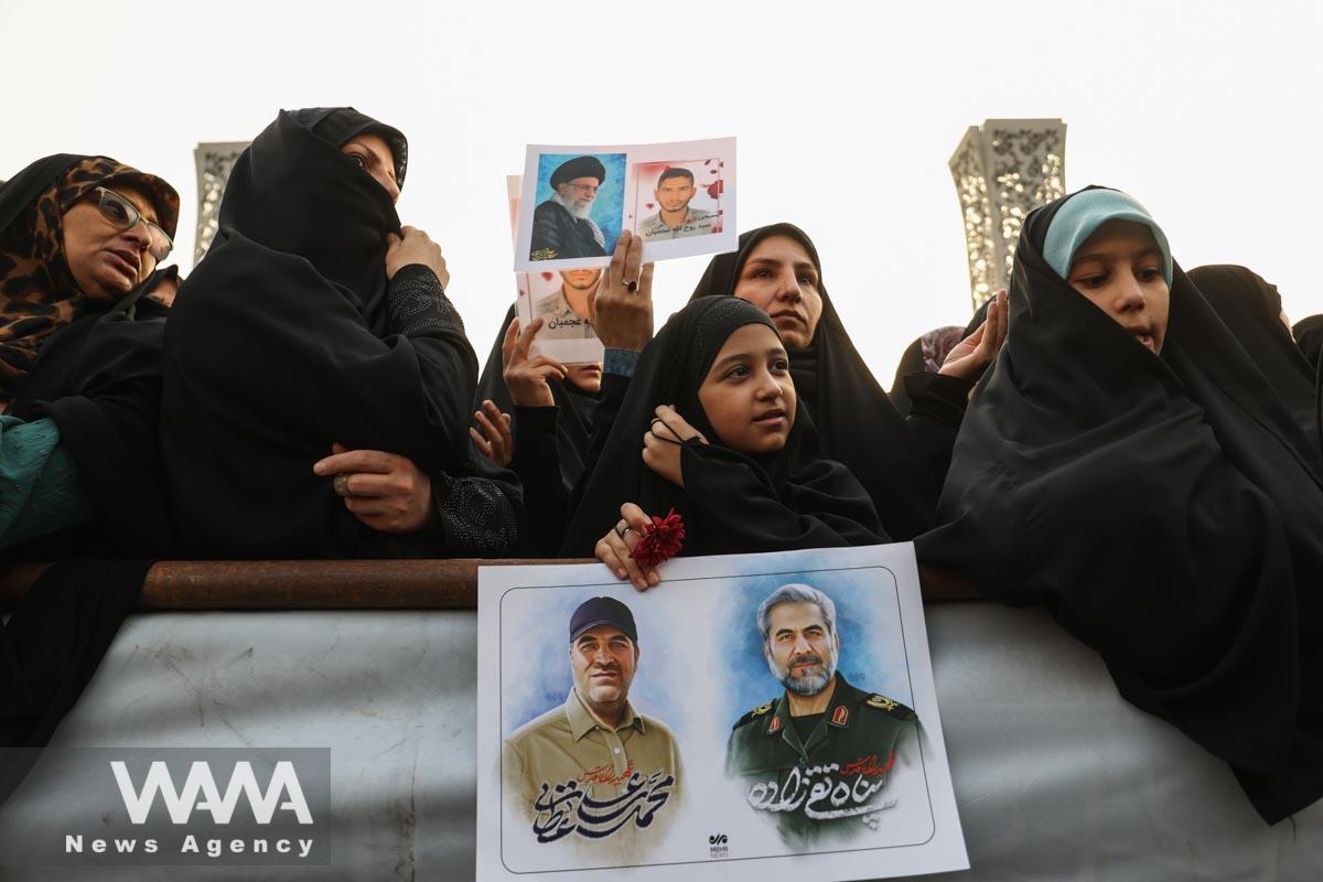 Iranian women hold pictures of Panah Taghizadeh and Mohammad-Ali Ataie, members of Iran's Islamic Revolution Guards Corps (IRGC) who were killed in an Israeli airstrike on Syria, during their funeral held in Tehran/WANA (West Asia News Agency)