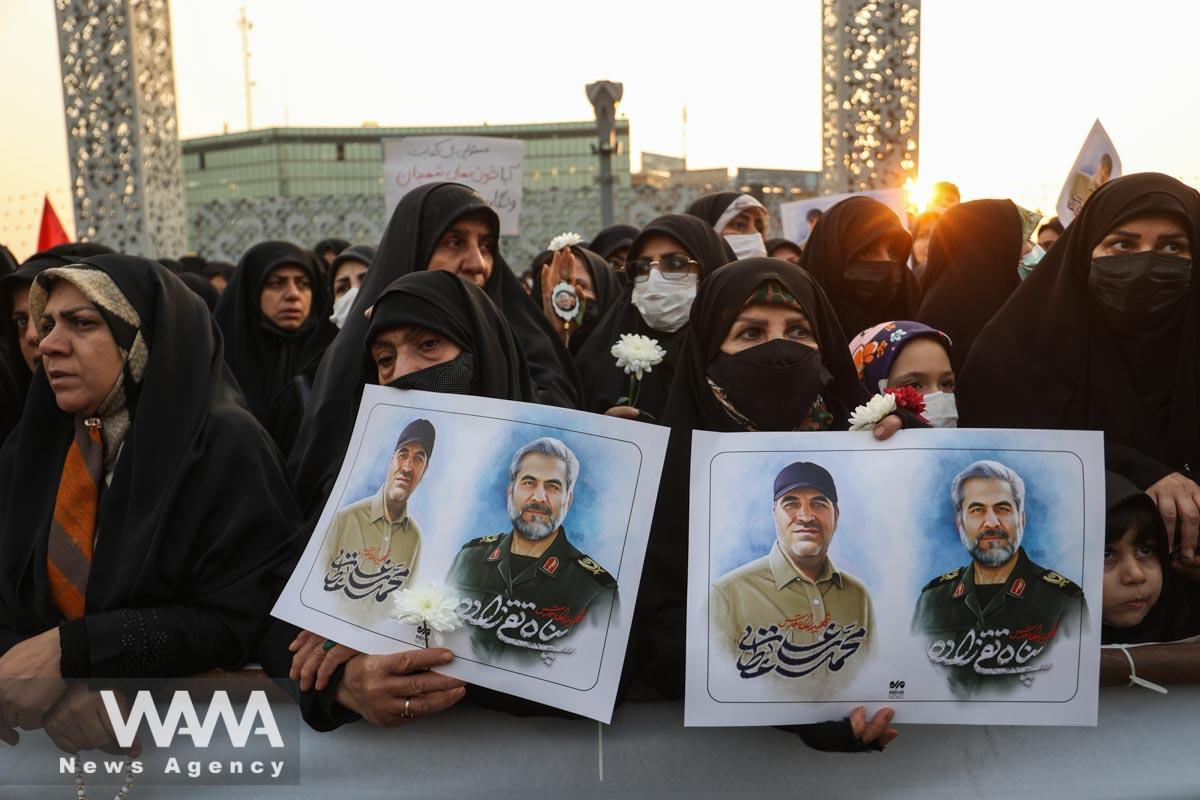 Iranian women hold pictures of Panah Taghizadeh and Mohammad-Ali Ataie, members of Iran's Islamic Revolution Guards Corps (IRGC) who were killed in an Israeli airstrike on Syria, during their funeral held in Tehran/WANA (West Asia News Agency)