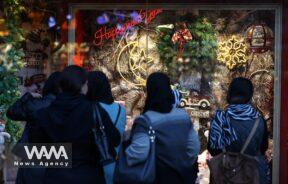 Iranian people look at a Showcase of a Christmas store/WANA (West Asia News Agency)