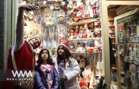 An Iranian woman takes a selfie with her child at a Christmas store/WANA (West Asia News Agency)