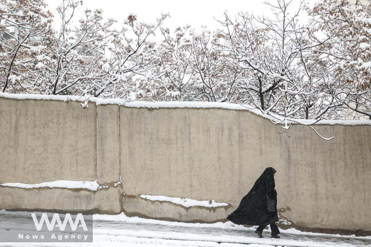 A woman walks during a snowfall in a street in Teheran, Iran/WANA (West Asia News Agency)