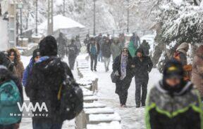 People walk during a snowfall in a street in Teheran, Iran/WANA (West Asia News Agency)
